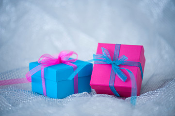 Gift boxes with ribbons on cloth background