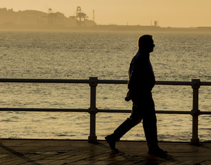 Hombre caminando al atardecer por la ciudad