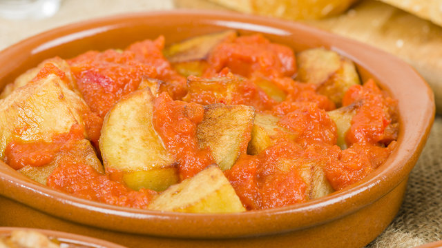 Patatas Bravas - Crispy potato chunks in spicy tomato sauce. Traditional Spanish tapas dish.
