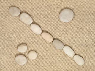 Fototapeta na wymiar Row of small stones on fiber background.