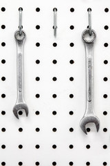 Missing wrench on white pegboard