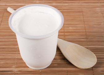 Sour cream and a wooden spoon on a table