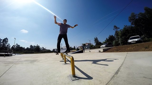 Slow motion extreme skateboarder sliding down rail