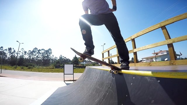 Slow motion shot of a skateboarder dropping a ramp.