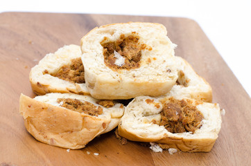 Bread slices on wood cutting board on white background
