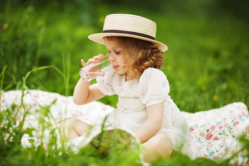 Little girl sitting and drinking