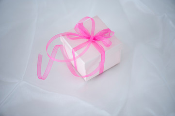 Gift box with ribbon on cloth background