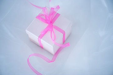 Gift box with ribbon on cloth background