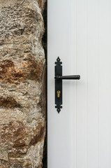 Detail einer weißen PVC Außentür neben einer Natursteinwand aus Granit