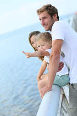 Fototapeta na wymiar Family standing on a pontoon looking at the sea