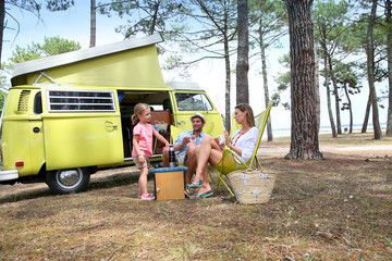 happy family relaxing by camper van in summer © goodluz