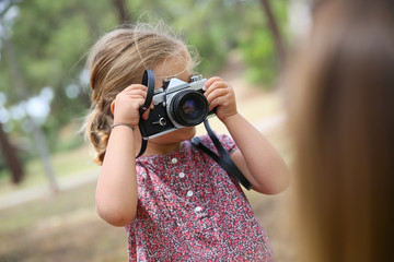 Portrait of little girl taking picture of her parents