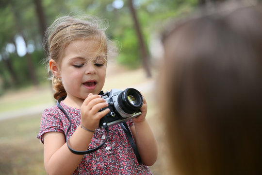 Portrait of little girl taking picture of her parents