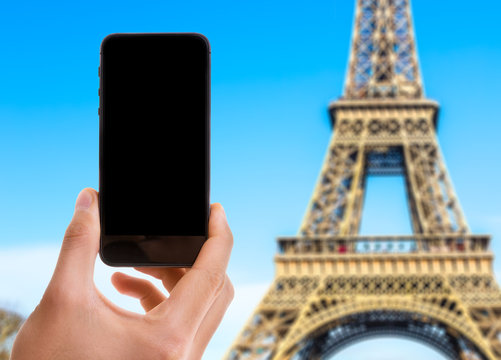 Phone with black screen with Eiffel Tower on background