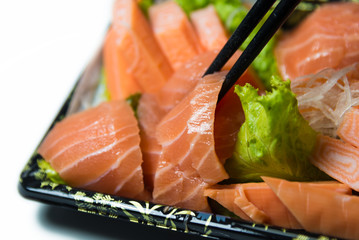 Chopstick grab a slice of Salmon Sashimi Japanese food   closeup