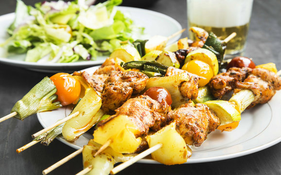 Chicken and Vegetables Skewers Grilled with Salad and Beer