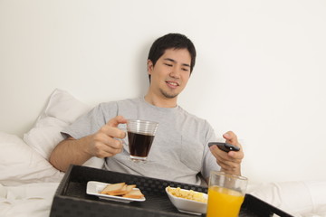 Man having a breakfast and watching tv