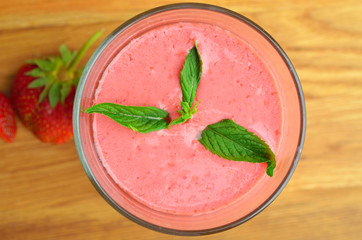 Top view of strawberry smoothies (on blurred old wood table)