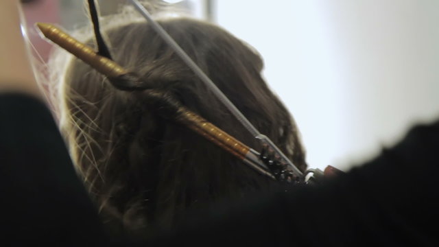 Stylist using curling iron for hair curls