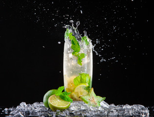 Mojito drink with splash on black background