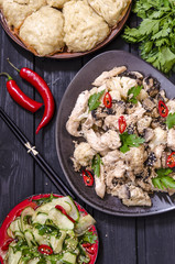 Lunch in the Asian style Chinese steamed buns, cucumber salad and steamed chicken, mushrooms and cauliflower in a sauce with chilli and herbs 