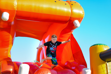 Young boy jumping on a plastic jumping castle