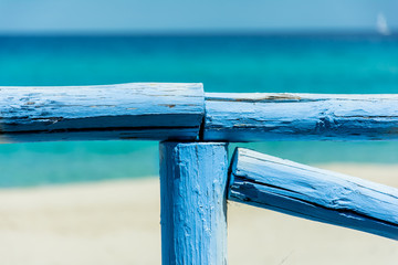 Detail of blue wood fence in front of the sea