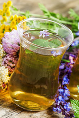 Fototapeta na wymiar Green hot tea with herbs in Islamic glasses, selective focus