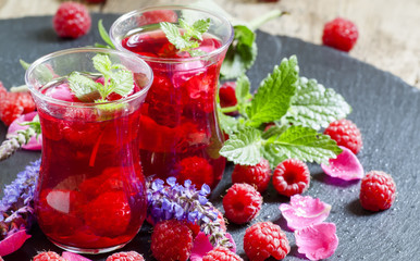 Hot red tea with raspberries, mint and rose petals, selective fo