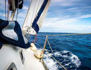 The white sails of yachts on the background of sea and sky in the clouds
