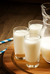 Fresh peasant milk jug and glasses on  wooden table, selective f
