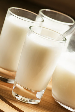 Fresh peasant milk jug and glasses on  wooden table, selective f