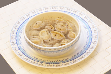 Russian pelmeni (meat dumplings) serving on white.