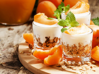 Homemade granola with yogurt and apricot in glass bowls, healthy
