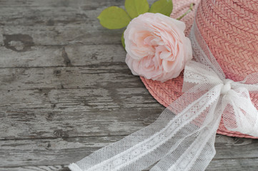 Sommerhut mit Rose auf Holzhintergrund 