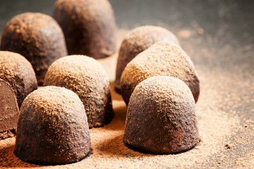 Fototapeta na wymiar Homemade chocolate truffles with cocoa powder on dark background