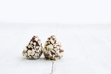 Chocolate truffles on white wooden background