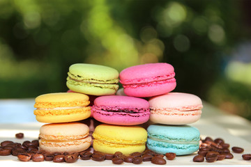 Colorful french macaroons with coffee on the nature background