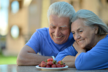 Senior couple in cafe with strawberries