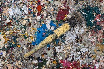 old used paint brush on dried pains splatter background
