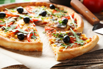 Fresh tasty pizza on brown wooden background