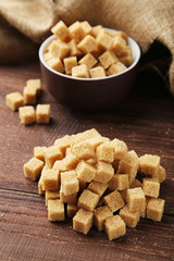 Brown sugar in bowl on brown wooden background