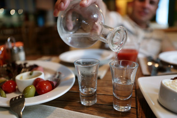 Man fills glasses of vodka