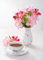 Retro still life with cup of tea and flowers (Alstroemeria)