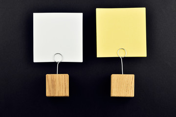 Two paper notes with holders on black background for presentatio