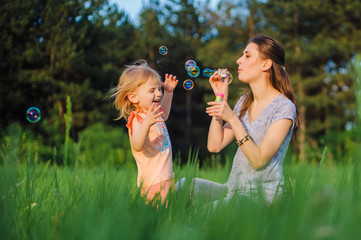 Mom and daughter blow bubbles