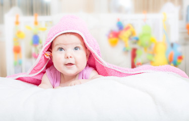 Little baby lying on the bed and smiling 