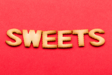 Fototapeta na wymiar Word sweets cookie over the red background