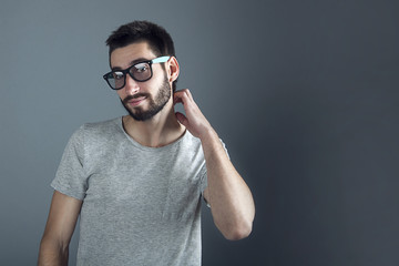 Fototapeta premium man with beard dressed casual smiling against gray wall