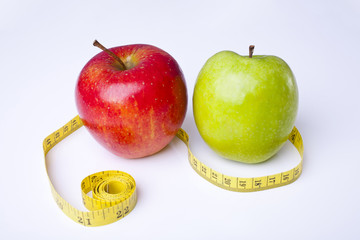 Apples red and green with measuring tape shot on a white background at an angle